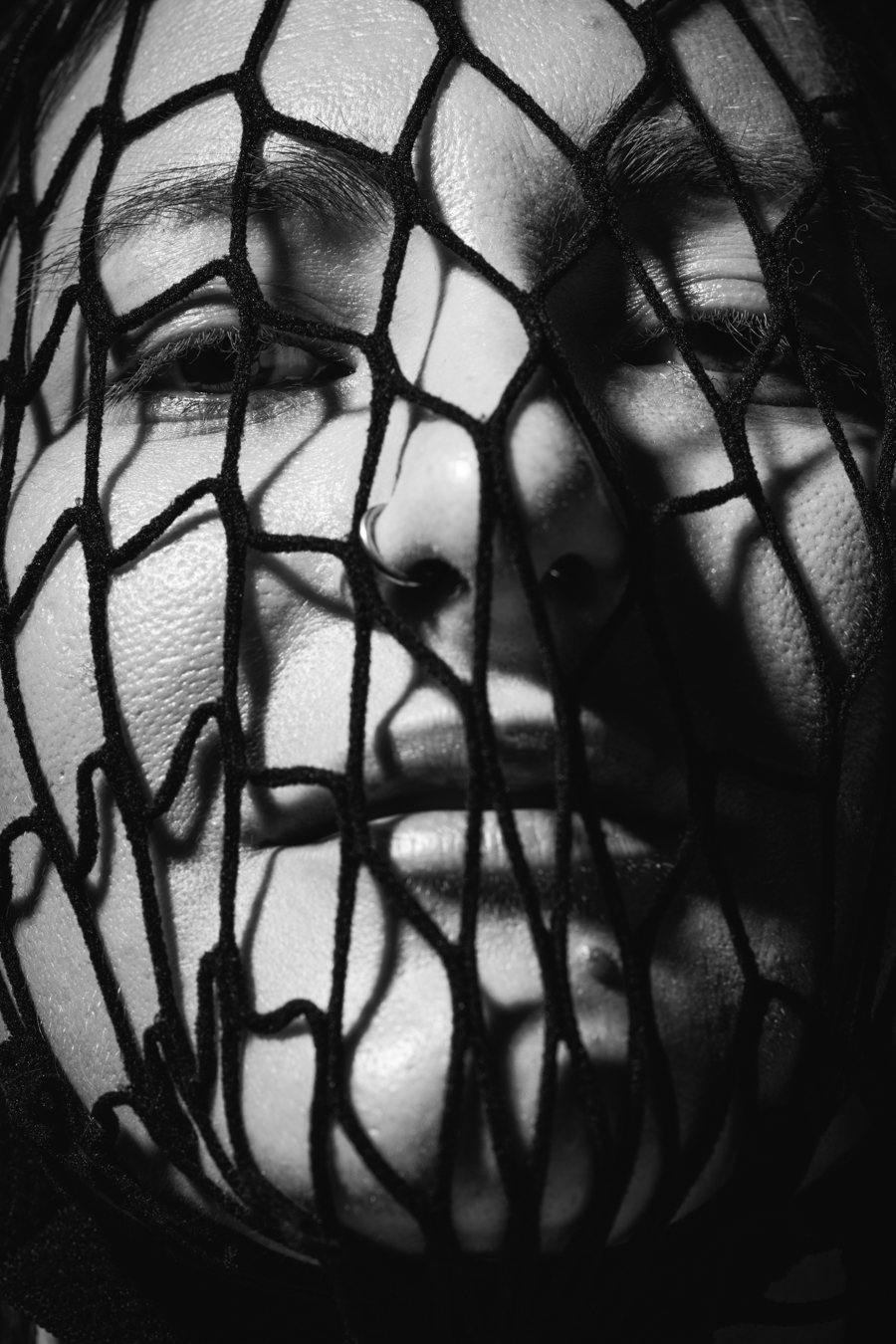 A woman with a net covering her face, creating a mysterious and intriguing visual effect.