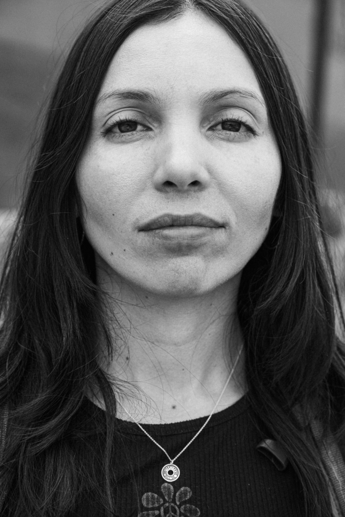 Portrait of a woman with long dark hair and a calm expression.