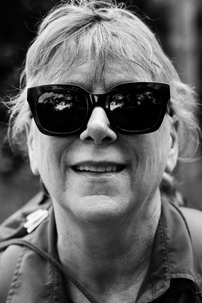 Portrait of a woman wearing sunglasses and smiling.