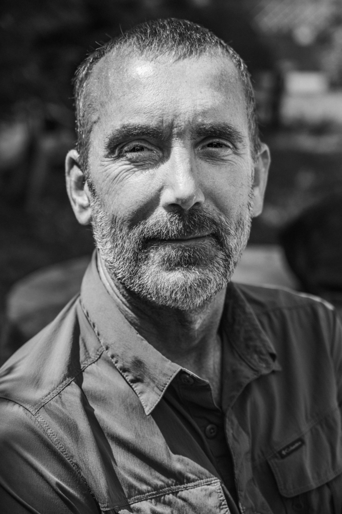 Portrait of a man with a beard and scarf looking into the camera.