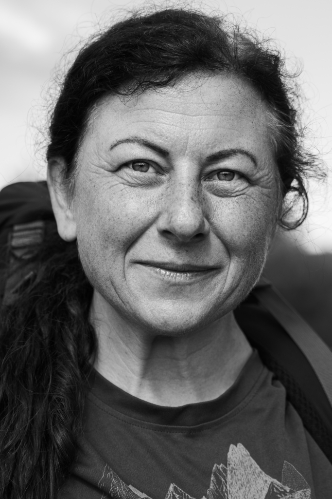 Portrait of a woman with dark hair tied back, slight smile.