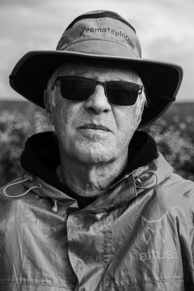 Portrait of a man outdoors wearing a hat and jacket, slight smile.