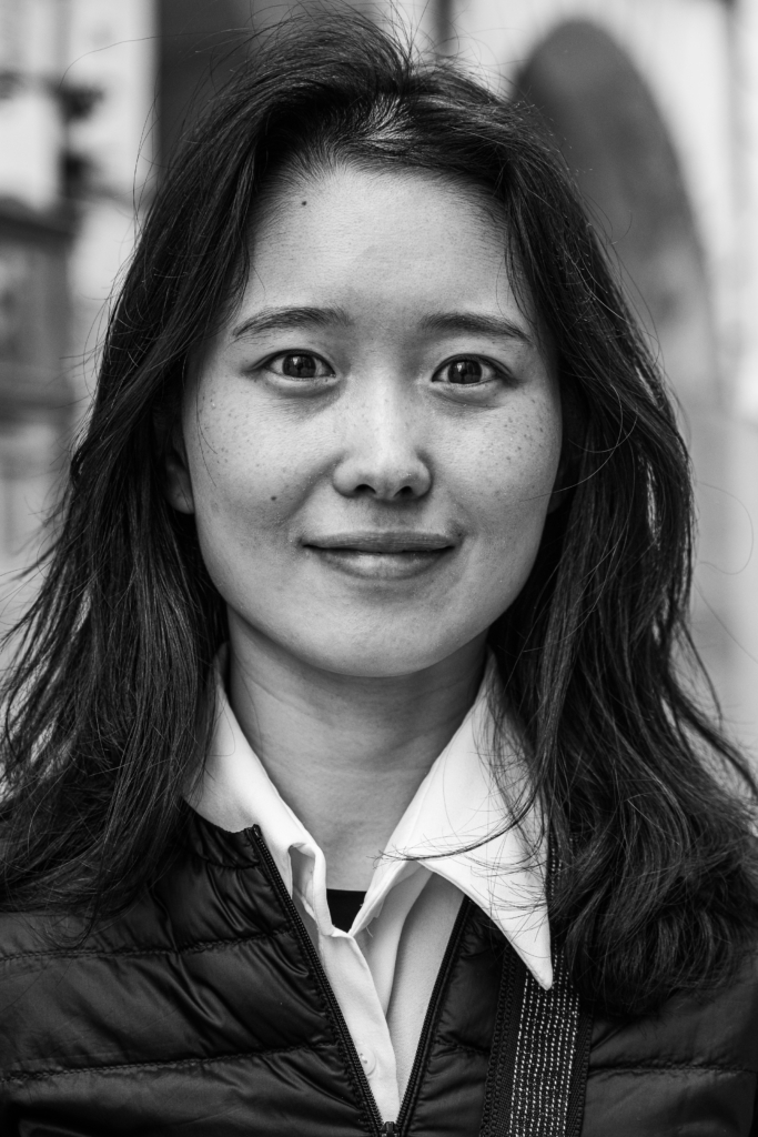 Portrait of a woman with long dark hair smiling softly.