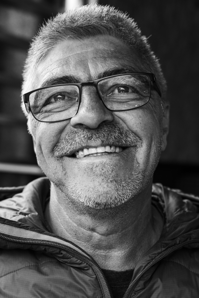 Portrait of a smiling man with glasses and a beard.