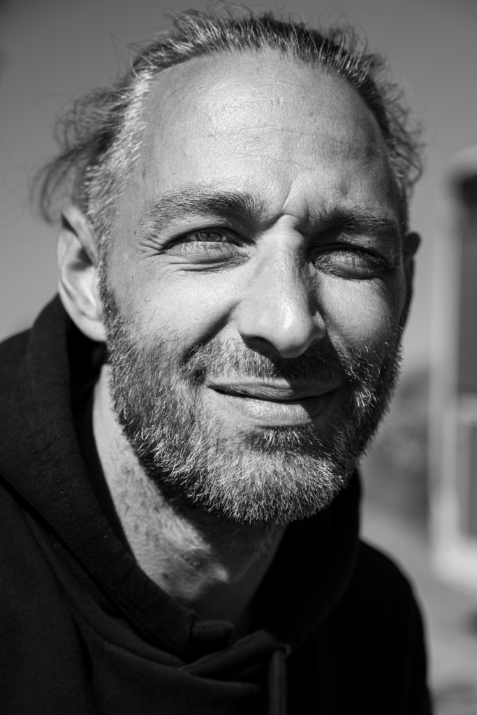 Portrait of a man with a beard smiling warmly.