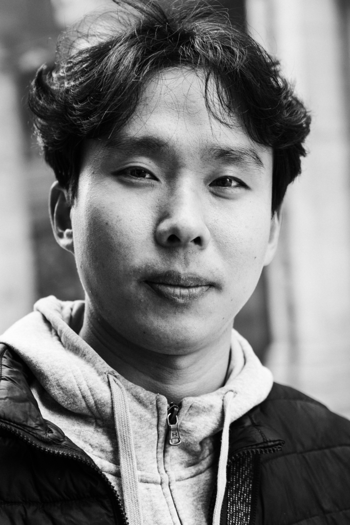 Portrait of a young man with short hair and a relaxed expression.