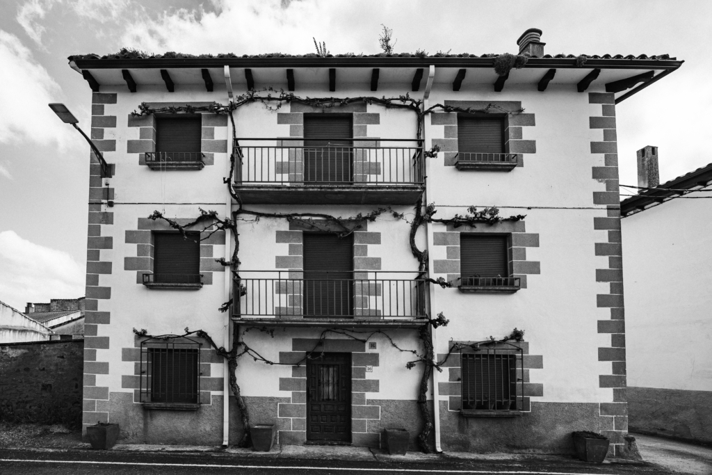 Close view of an old building facade with weathered textures and windows.
